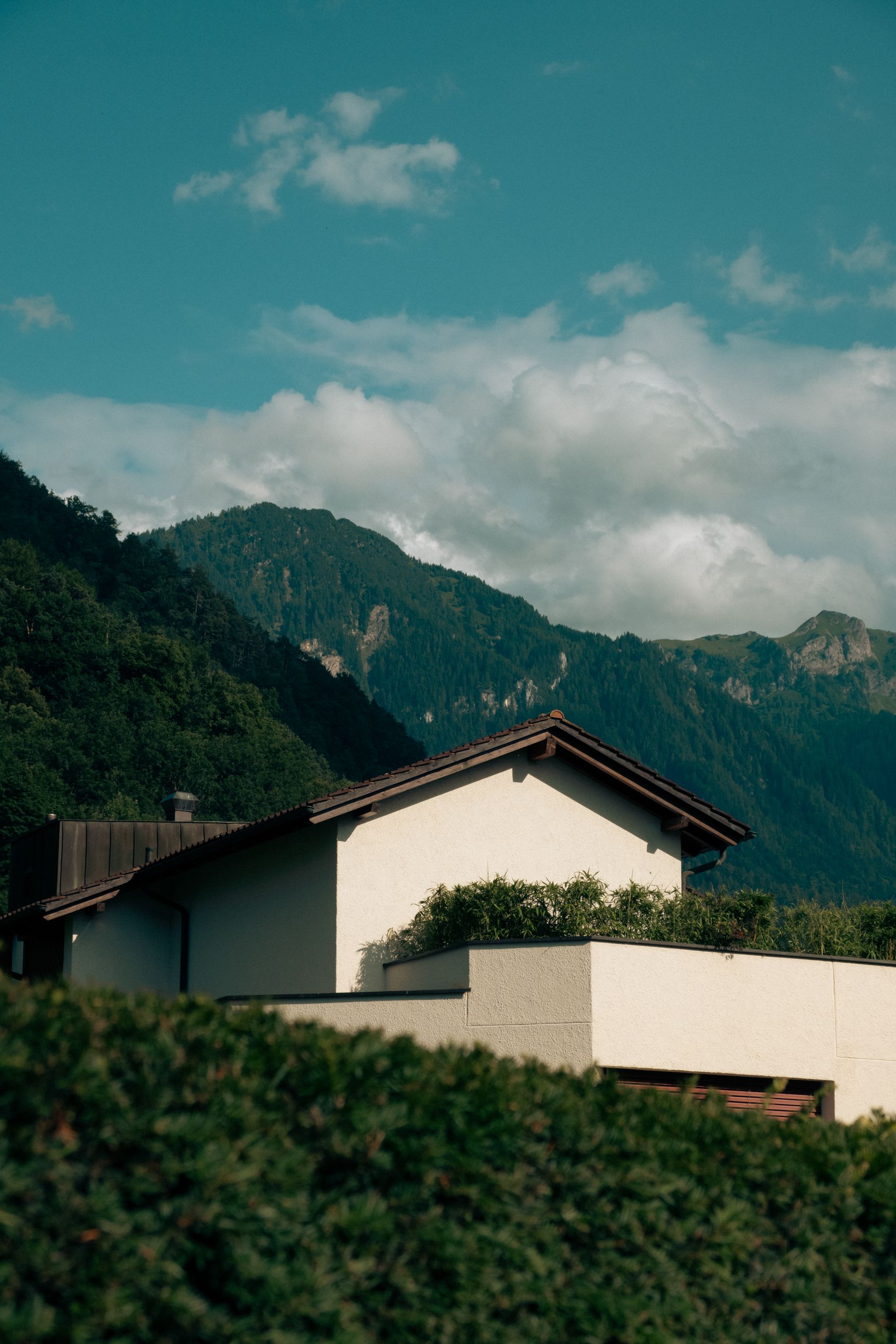 Façade claire d’une maison au pied des montagnes